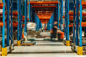 Someone on equipment driving through warehouse.